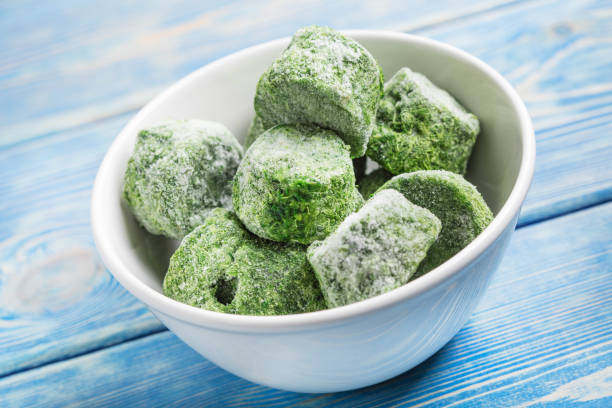 Frozen spinach blocks. Frozen spinach blocks in white bowl. Selective focus. dog frozen treats green stock pictures, royalty-free photos & images