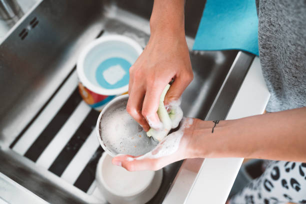 Woman hands washing a dog bowl Unrecognizable woman hands washing dog bowl in the kitchen sink. dog dishes cleaning stock pictures, royalty-free photos & images