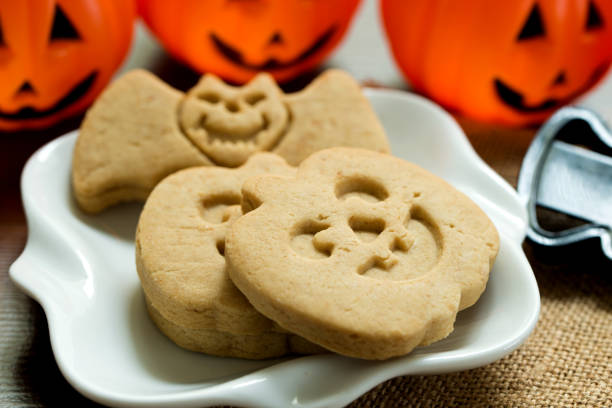 Halloween homemade cookies Halloween homemade Jack O'lantern pumpkin cookies served on plate jackolantern cookies stock pictures, royalty-free photos & images