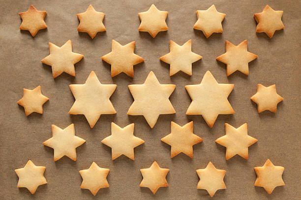 christmas cookies christmas cookies in star shape on baking paper star cookies stock pictures, royalty-free photos & images