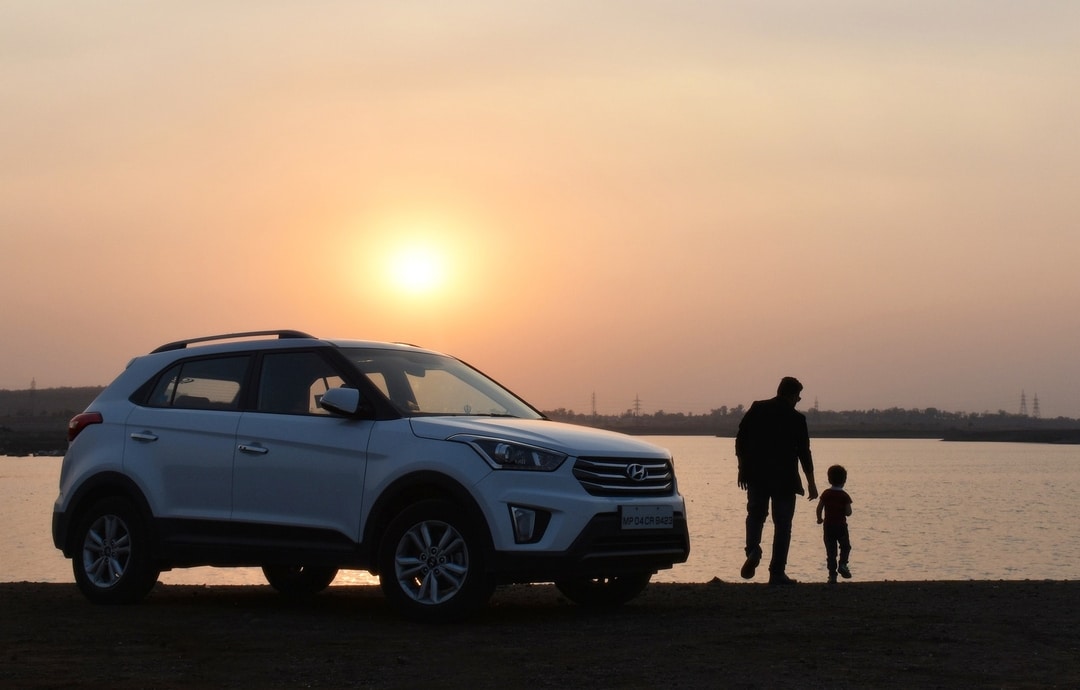 Family with white car beside the water