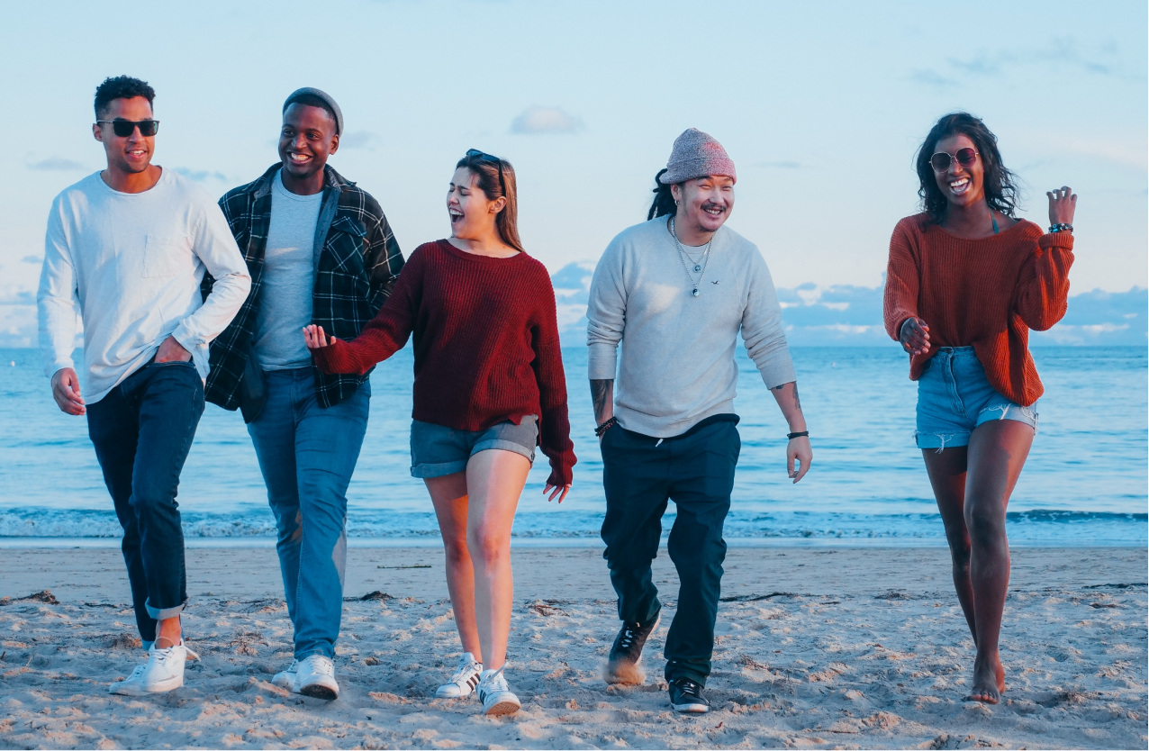 A group of friends living with epilepsy walking on a beach