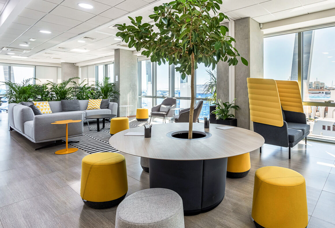 A modern, energized and motivating office design with lots of plants and yellow accents for the forex company Exness.