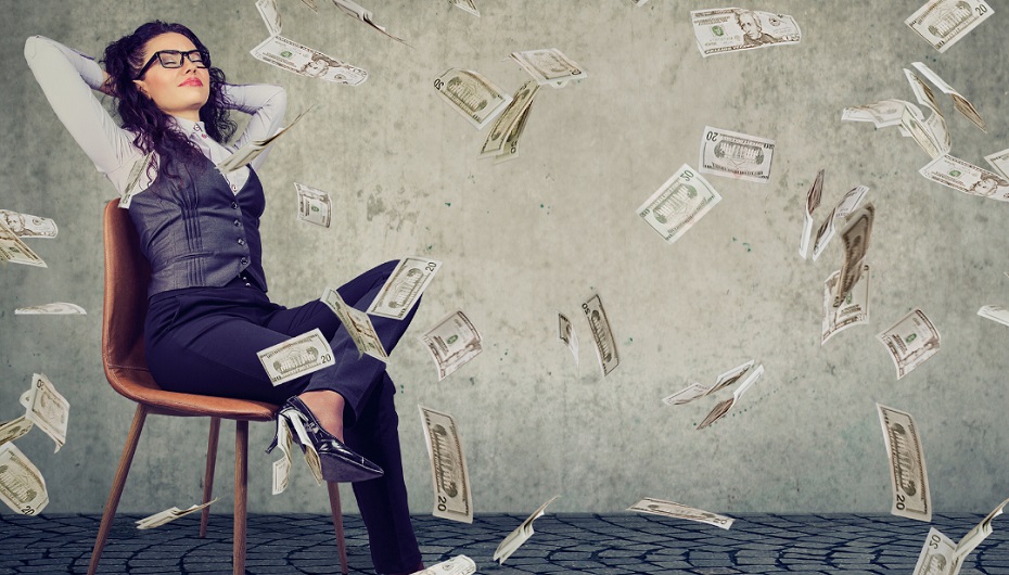 A contented looking woman leans back in a chair as paper money rains down around her.