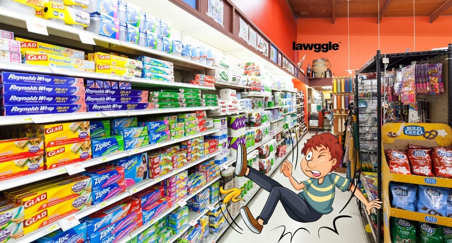 A person slips on a banana peel and falls down in a grocery aisle.