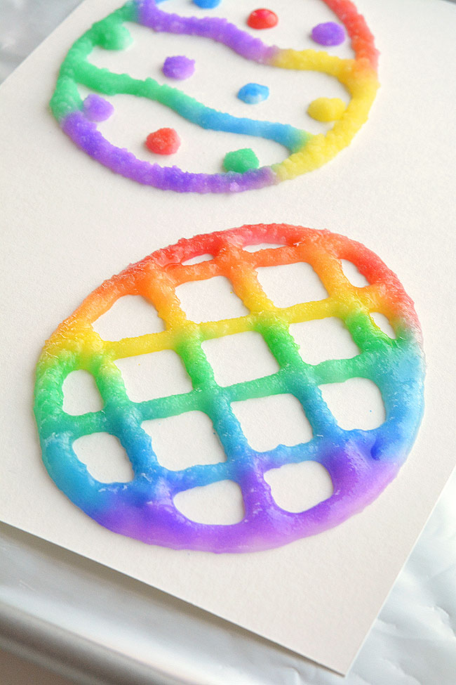 These salt painted Easter eggs are such a fun and easy craft idea for spring time! With a little bit of salt and glue you end up with colorful puffy paint like shapes with an awesome texture! They even stay puffy after they dry. Cut out the eggs to make an Easter basket craft, or you can make cute DIY Easter cards! This is such a great Easter craft for kids!