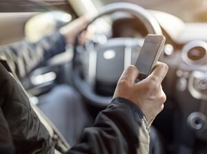Person Looking at Cell Phone While Driving