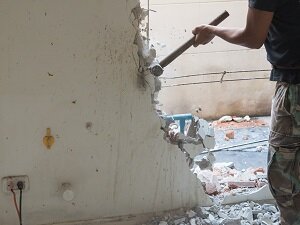 Worker Using Sledgehammer to Demolish a Wall