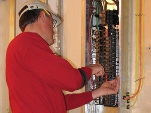 Electrician working in electrical panel