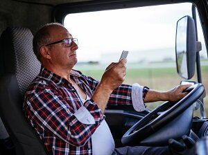 Trucker looking at cell phone while driving