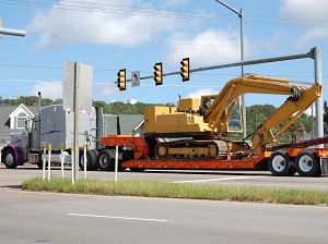 Truck Hauling Excavator Down City Street