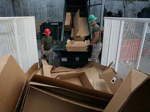 Two Workers Loading Cardboard into Recycler
