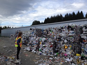 Worker Standing by Stacked Recycling