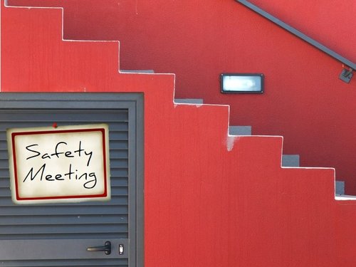Red Wall, Stairs, Sign on Door Says Safety Meeting