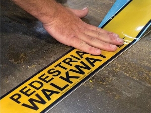 Laying Down Hazard Tape That Says Pedestrian Walkway