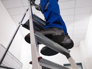 Worker Standing on Step Ladder
