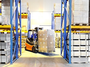 Forklift Carrying Load in Aisle of Warehouse
