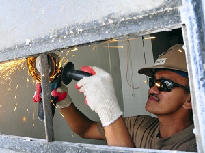 Gloved Worker Grinding Metal