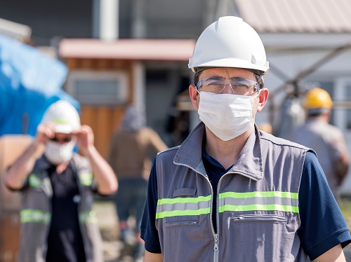 Two Workers with Face Masks Standing Apart