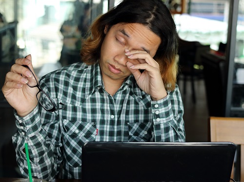 Person Rubbing Eyes After Working on Computer