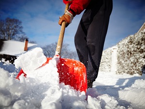 Person shoveling snow near their home.