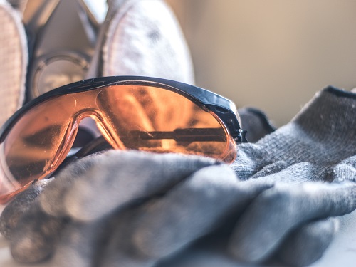 Safety glasses with a respirator and work gloves.