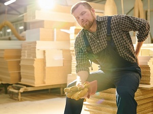 Construction worker sitting down because his back hurts.