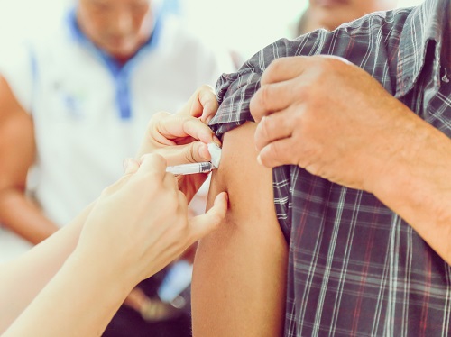 Person receiving a flu vaccine shot.