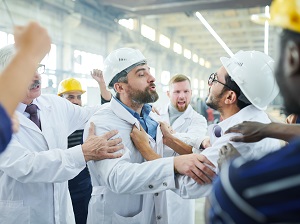 Two angry workers that look like they are fighting with each other while other workers surround them.