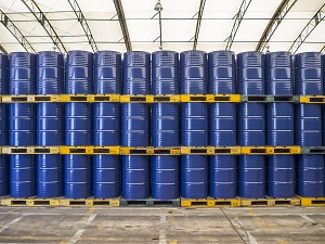 Blue industrial drums stacked neatly on pallets three tiers high.