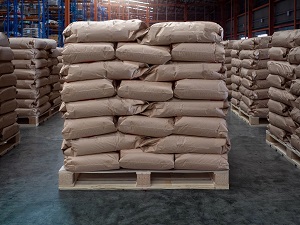 Bags are stacked in an interlocking formation on top of a pallet inside a warehouse.