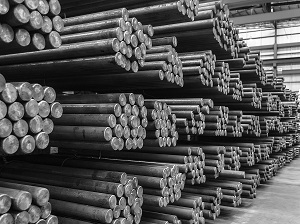 Steel rods stacked carefully on metal racks inside a warehouse.