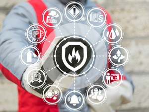 A worker wearing safety gear in the background touching a graphic with fire safety logos.