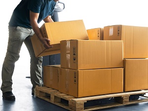 Worker putting boxes onto a pallet.