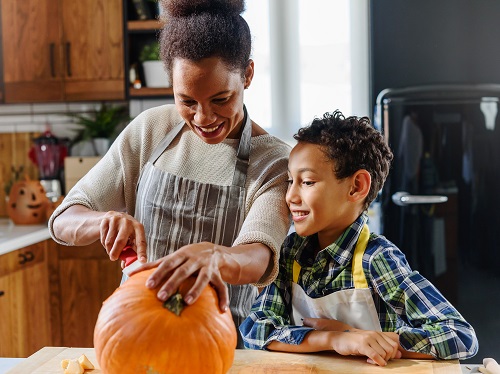 A family safely enjoying the tradition of pumpkin carving together.
