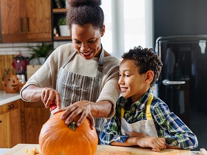 A family safely enjoying the tradition of pumpkin carving together.