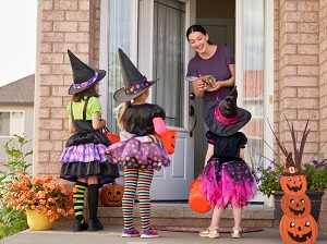 Three young children in costumes who are trick-or-treating.