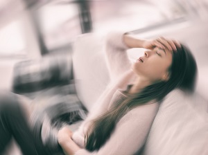 Woman sitting on couch who appears to be very ill.