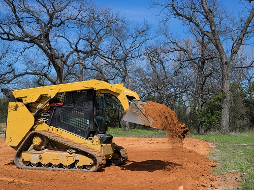 A skid-steer loader in operation at a job site.