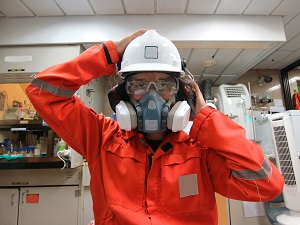 Worker wearing a hardhat demonstrating the use of a respiratory protection system.