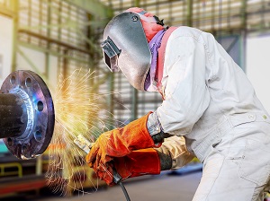 A welder wearing full-body protective equipment.