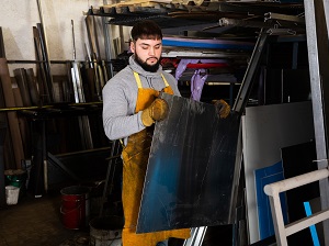 A worker wearing a heavy work apron and leather work gloves.