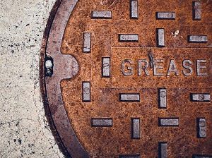 A large grease trap cover that looks similar to a manhole cover.