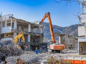 Heavy equipment tearing down an old building.