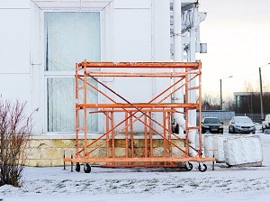 A mobile scaffold outside a building lowered and not currently in use.