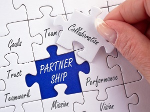A puzzle with pieces that say words like collaboration and partnership.