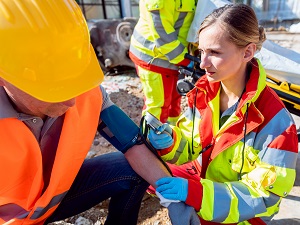 Medical professional providing assistance to a construction worker at the job site.