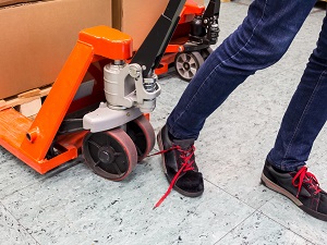 A person with an un-tied shoe that got their shoelace caught in a pallet jack.