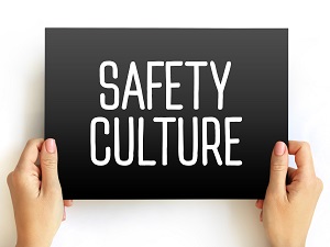 Two hands holding a black sign that says "Safety Culture" in white letters.