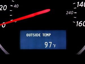 A view of the thermostat inside of a car showing that the outside temperature is 97 degrees.